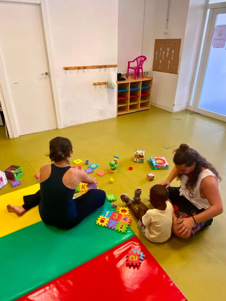 Una educadora i infants juguen en un dels espais Minuts Menuts de Salt