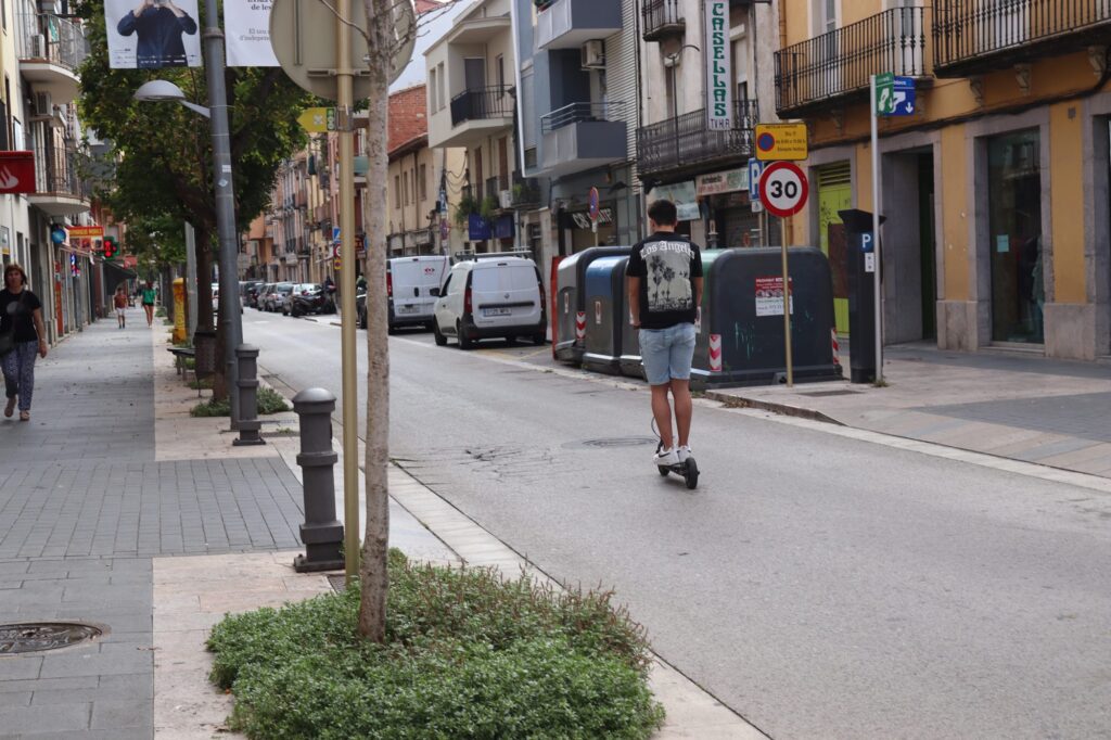 Persona amb patinet elèctric en un carrer de Salt